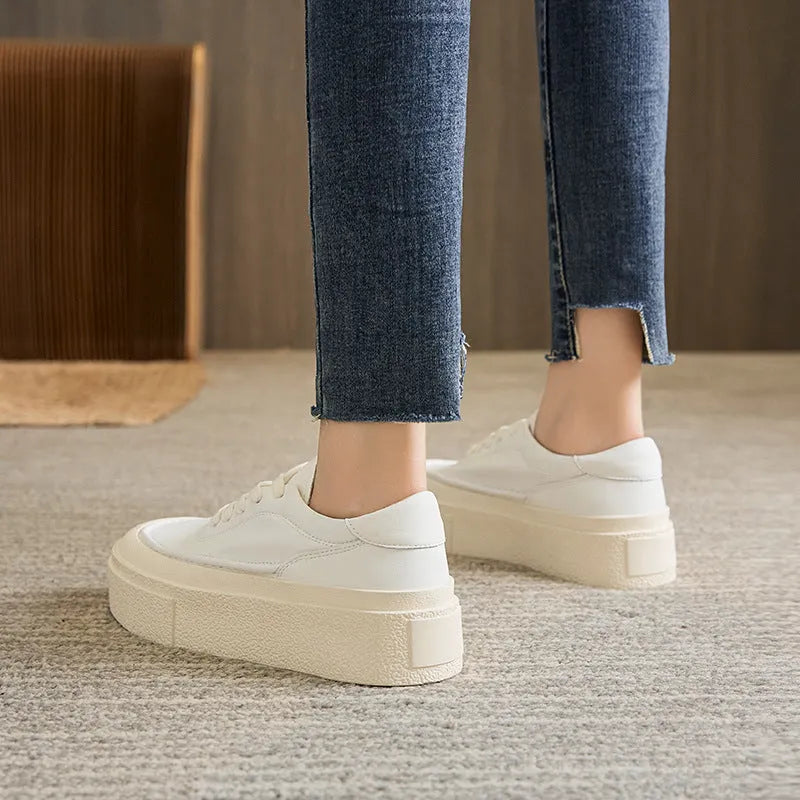 Black and white women's embossed leather platform sports shoes with a round toe and rubber sole.