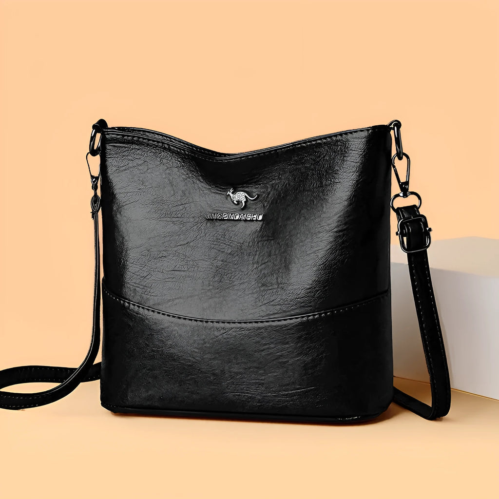 Women's black soft leather bucket-style shoulder bag with minimalist design and visible stitching