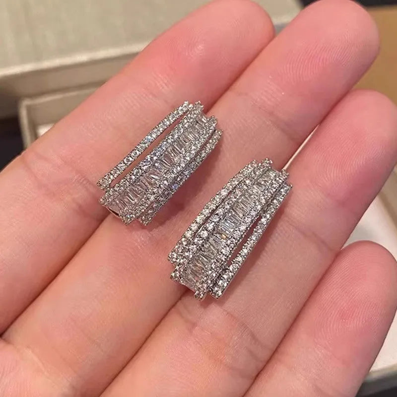A pair of geometric-shaped stud earrings with zircon stones in a white gold colour.