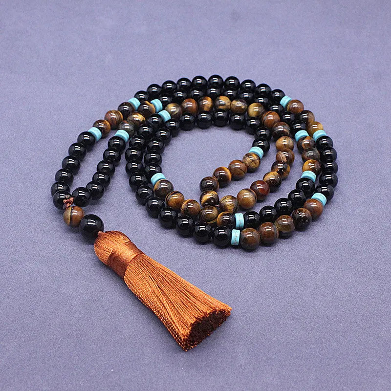 Black agate bracelet and matching tiger's eye geometric necklace set on a plain background.