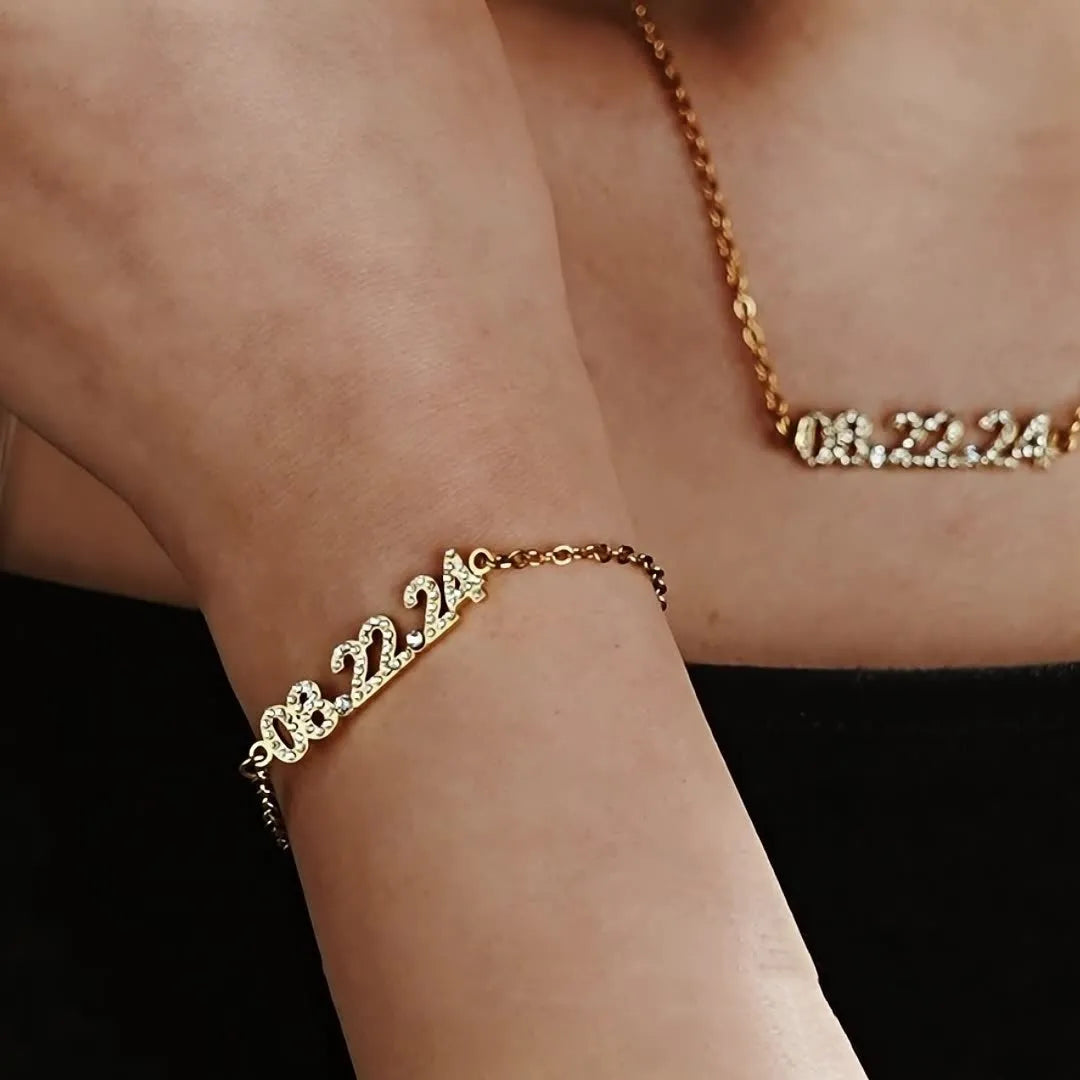 Stainless steel digital bracelet and necklace with diamond-set numbers in gold, rose gold, and steel finishes.