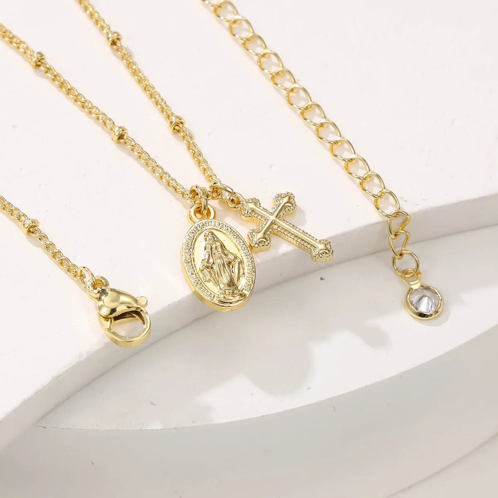 Gold-coloured copper necklace with a geometric cross pendant featuring a Virgin Mary centrepiece.