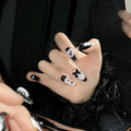 Black and pink peach heart hand-painted artificial nails with bow patterns in cat's eye finish