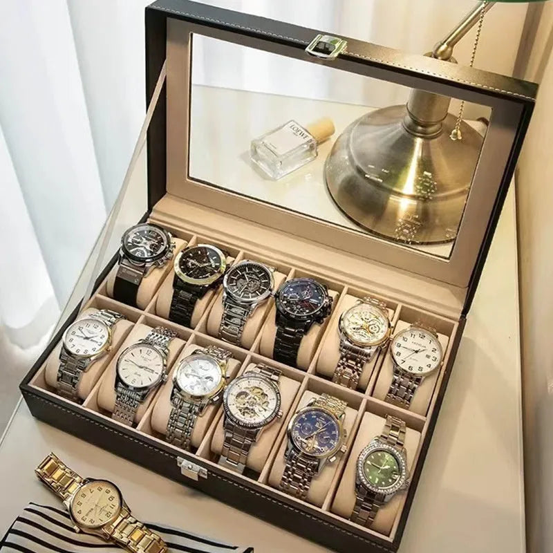 Grey leather watch storage box with clear dustproof lid showing multiple watch compartments inside.