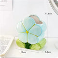 Ceramic pen holder storage box with floral decoration on desk.