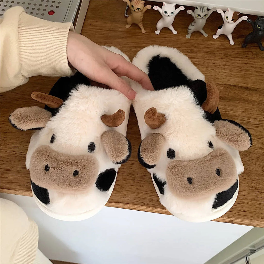 White cow print faux fur plush slippers for women with a non-slip textured sole.