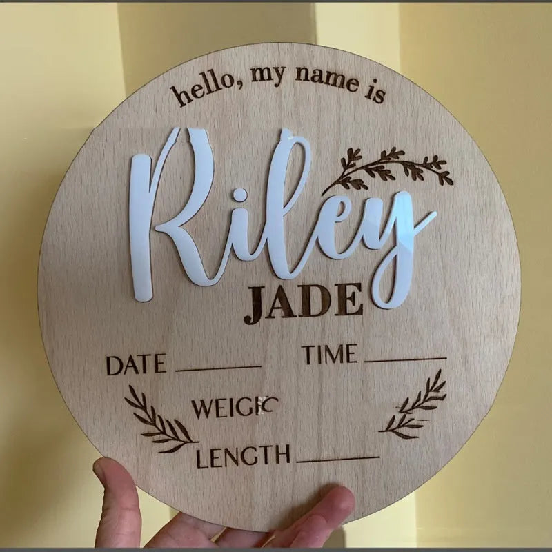 Square wooden newborn name label with baby birth information displayed on plywood