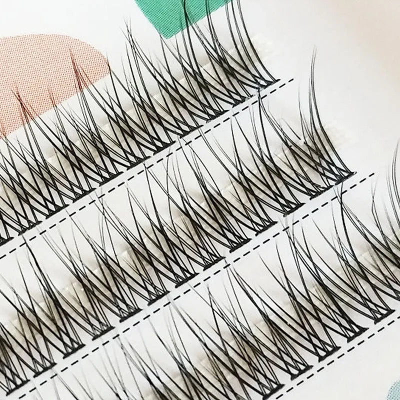 Black V-shaped fairy fishtail false eyelashes with thick segments on a clear lash band.