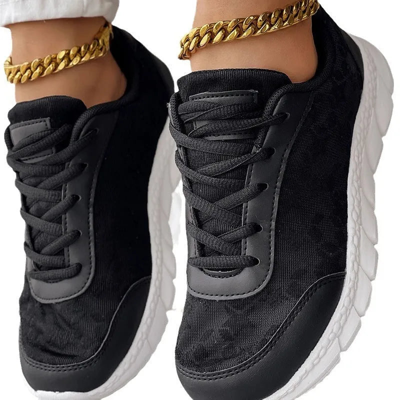 Women's white canvas sports shoes with round toe and flat heel on a neutral background.