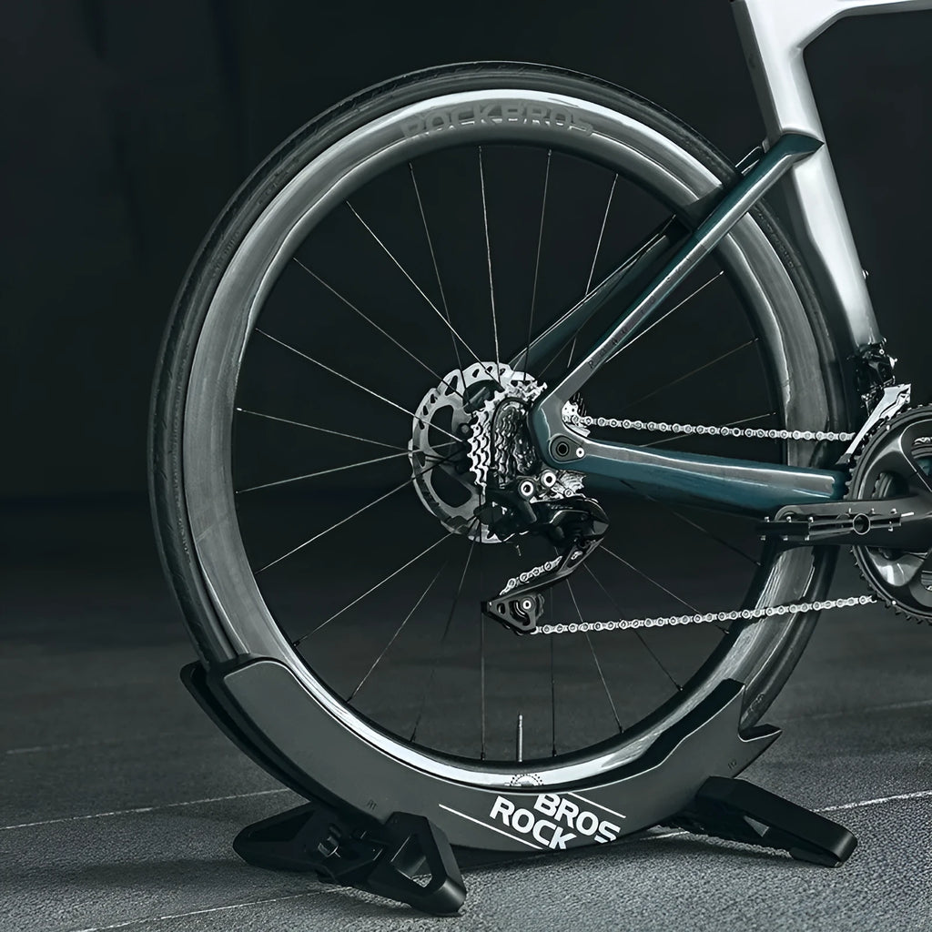 Black and green ABS plastic bicycle parking rack holder with fixed mounting bracket.