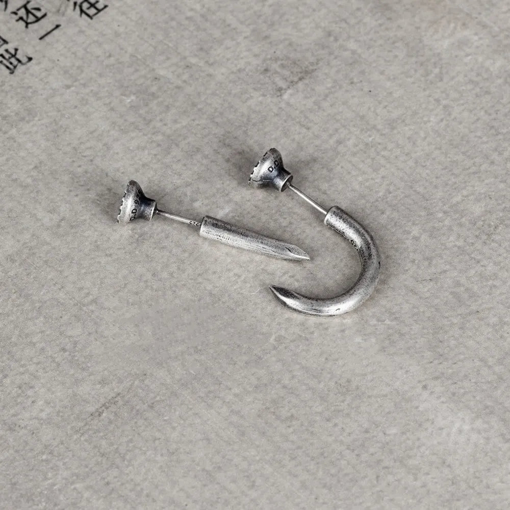 Sterling silver punk-style nail stud earrings on ear hook, showing straight and curved nail designs.