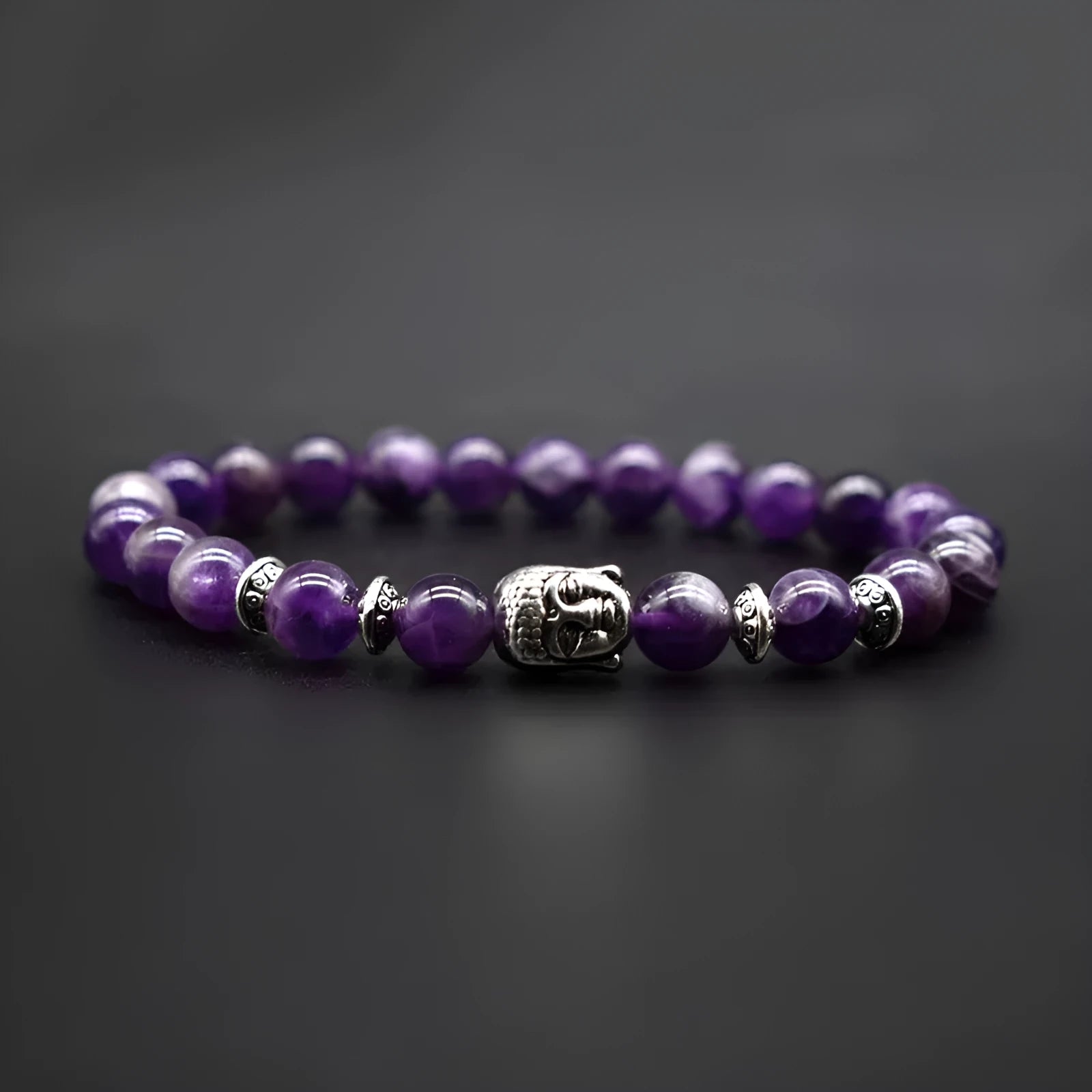 Close-up of a handcrafted tiger eye bracelet with a detailed Buddha head bead on a wrist.