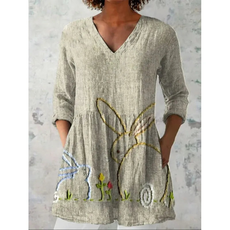 Printed women's loose dress with wide waist and three-quarter length sleeves on a hanger.