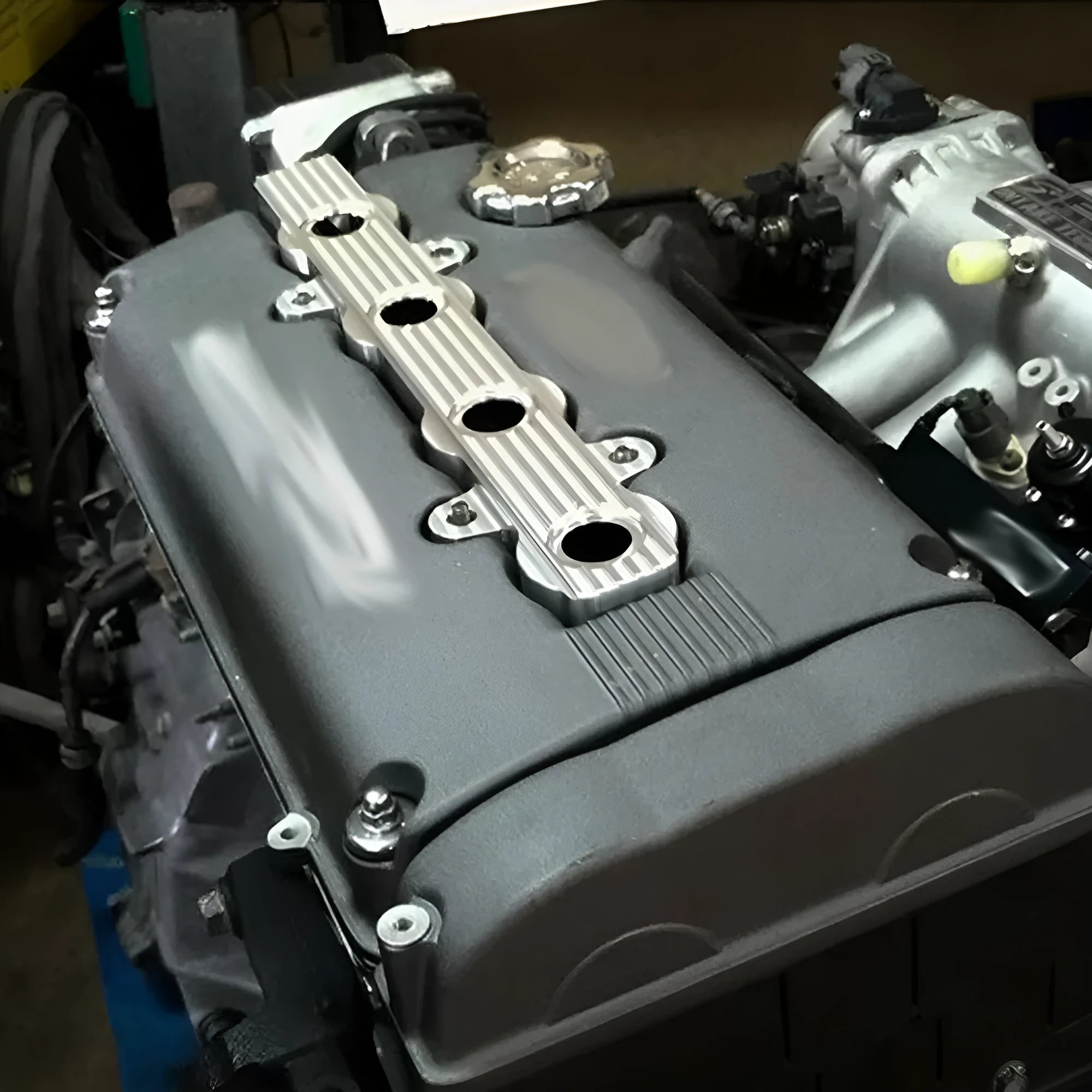 Aluminium alloy engine harness housing cover in blue, red, and silver colours, showing versions with and without holes.