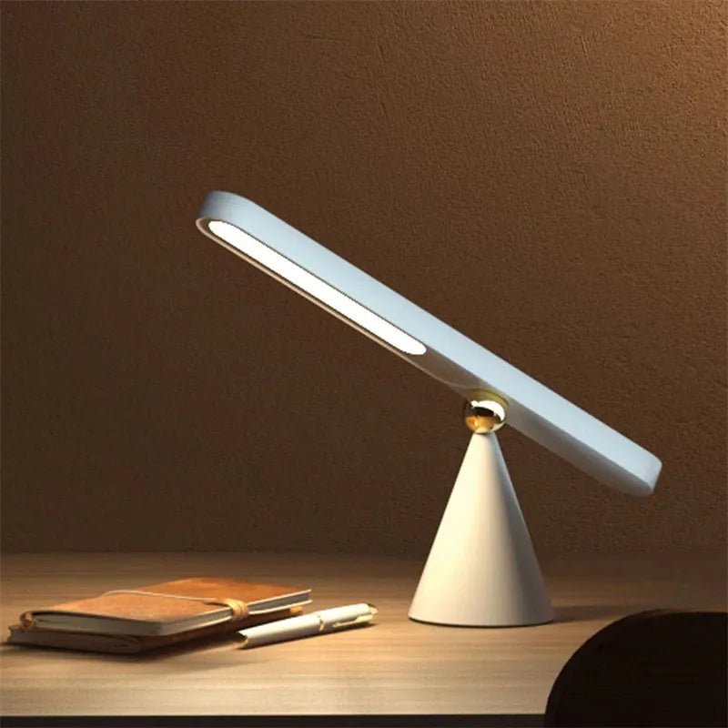 White geometric desk lamp with magnetic suction base and touch control on wooden desk