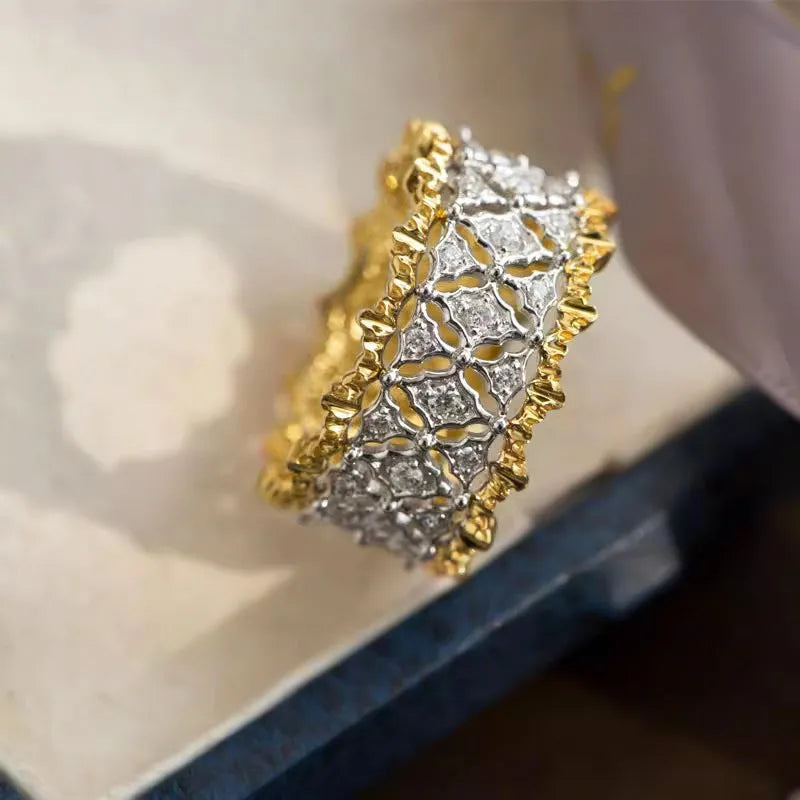 Geometric two-tone copper ring with a round zircon stone, shown on a finger.
