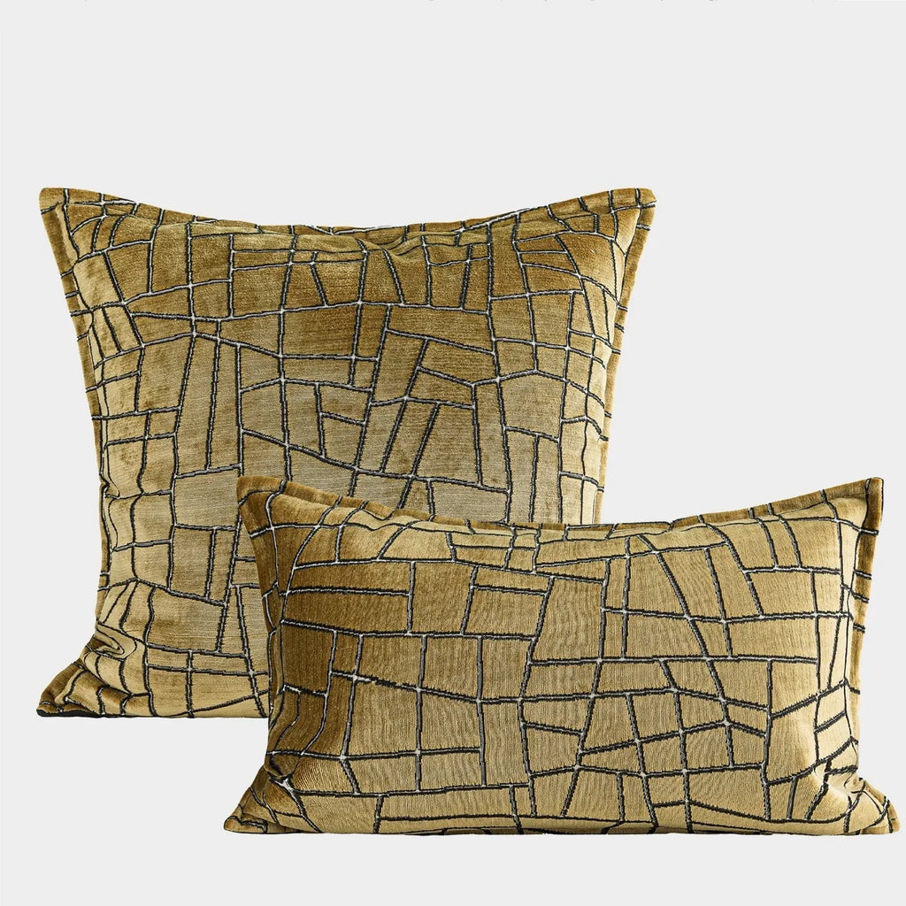 Gold geometric abstract pattern on a square polyester cushion cover and a lumbar pillow.