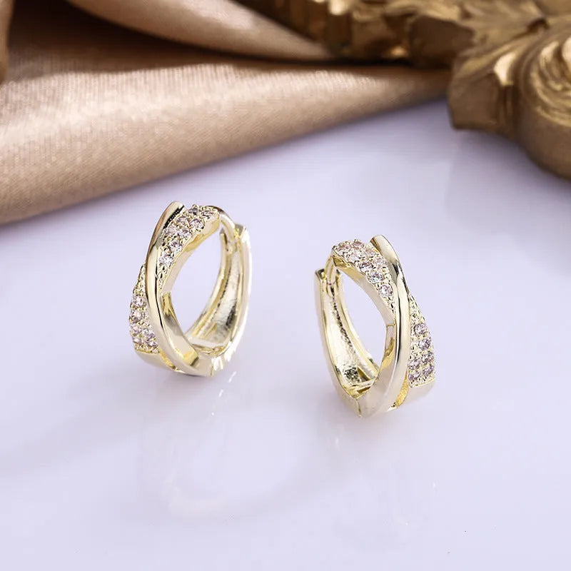 Pair of geometric drop earrings in 14K yellow with zircon treatment on a copper base.