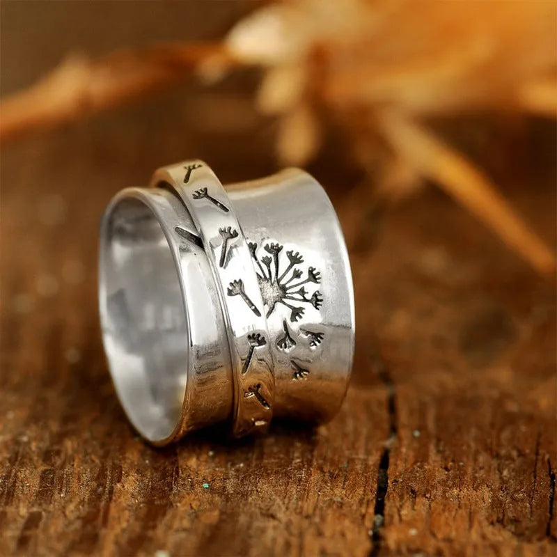 Rotatable silver-colour flower ring showing adjustable design on finger