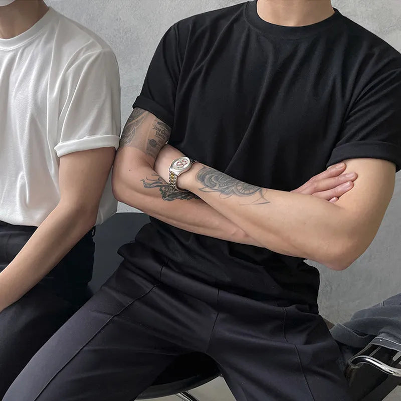 Man wearing a slim fit black cotton t-shirt with a round neck and regular sleeves.