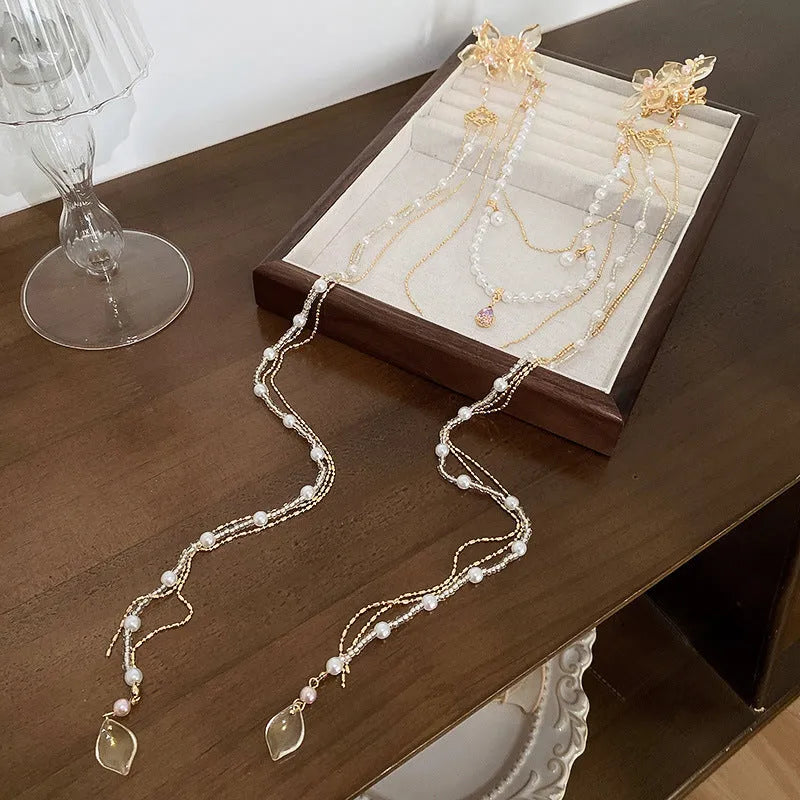 Gold women's hairpin with pearl, diamond and flower design featuring long tassel decoration