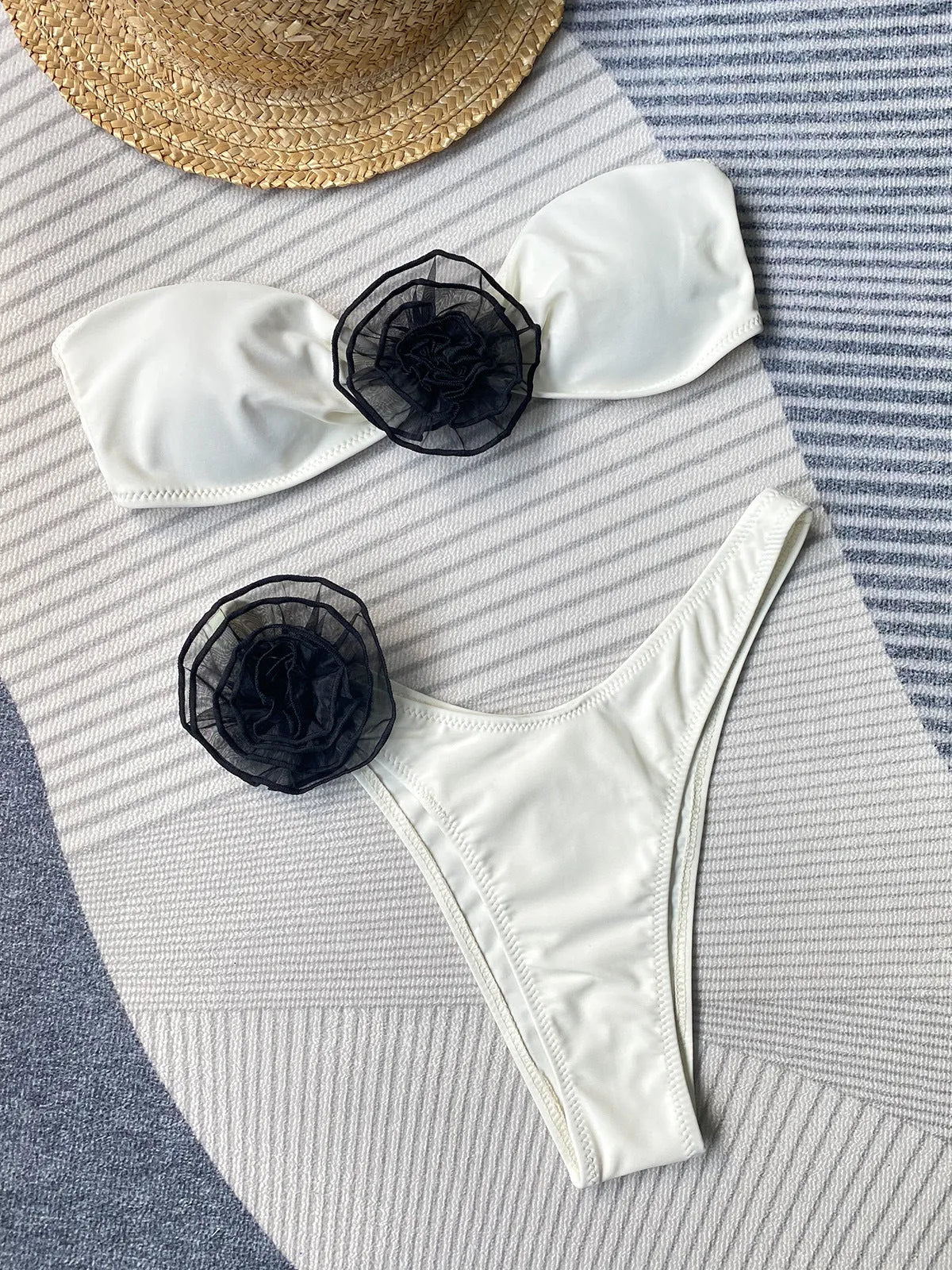 Black striped bikini set with flower detail tube top and split shorts on a mannequin.