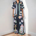 Black women's casual set with cartoon print, featuring sleeveless cardigan and trousers.