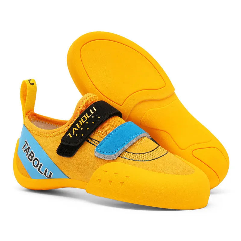 Beginner rock climbing shoes with Velcro strap and rubber sole in black and red colour.