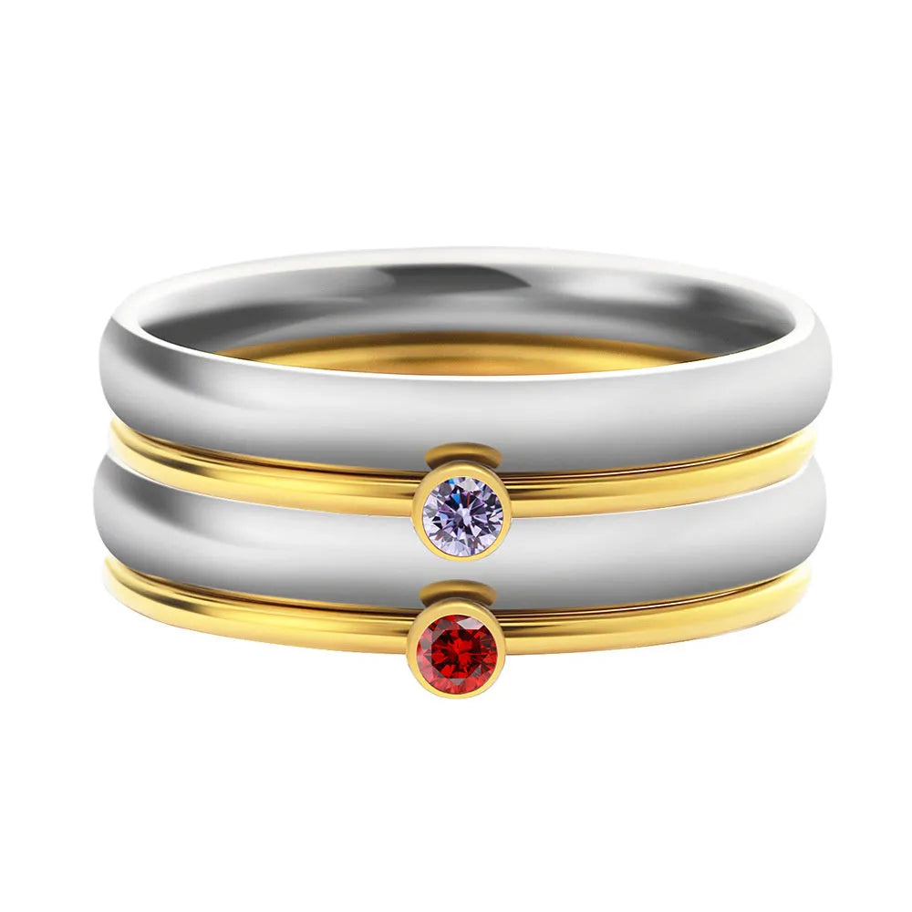 December birthstone geometric engraved ring in titanium steel with gold-coloured handle on a grey background.