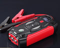 Red car emergency jump starter with digital display and thick battery clips