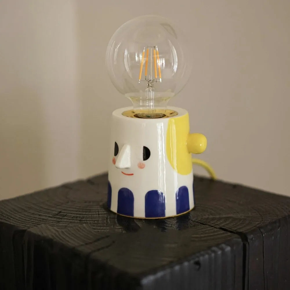 Handmade ceramic lamp with ball headlight design on bedside table