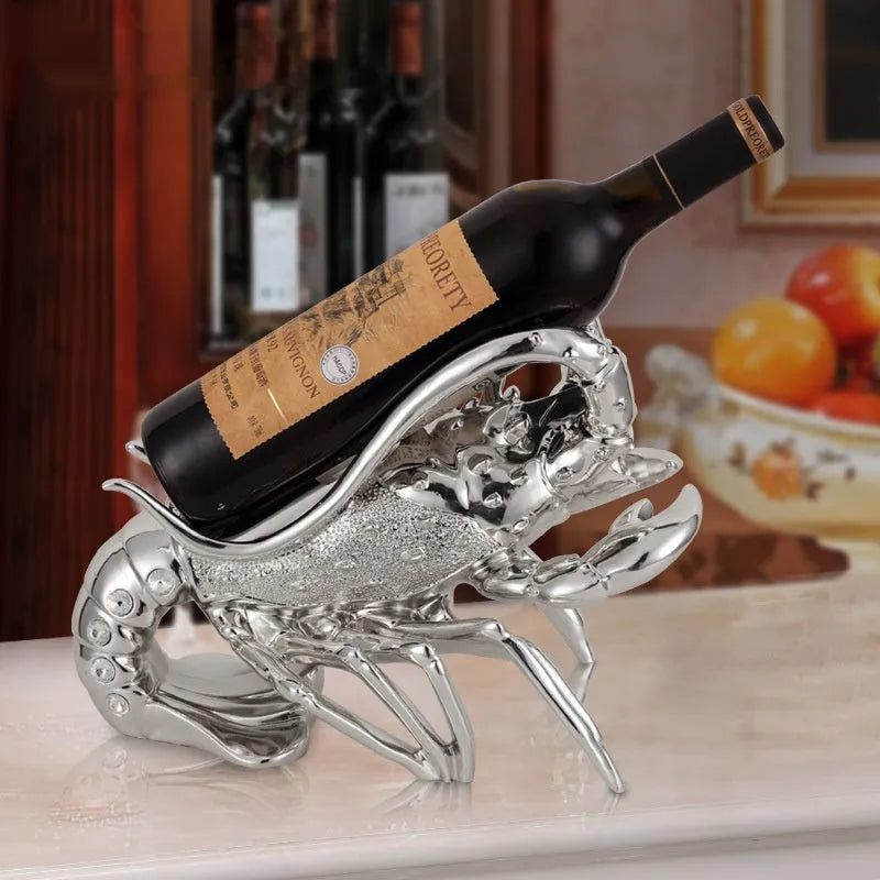 Rose gold and silver lobster-shaped plastic and resin wine rack ornament on a tabletop.