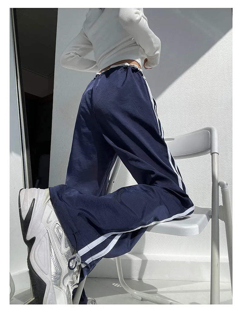 Navy blue loose straight-leg trousers with white parallel ribbon detail on the legs.