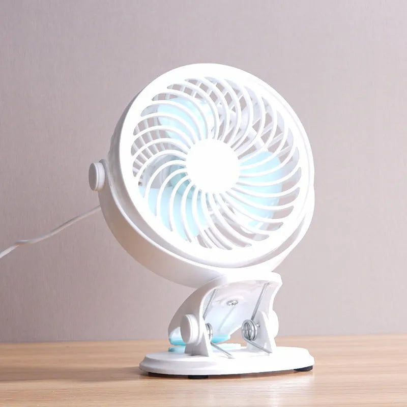 Small white USB desk fan with three blades, shown both clipped to a surface and standing on a desk.