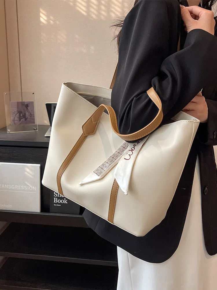 Large soft tote shoulder bag in khaki colour with a crossbody strap and visible sewing line detail.