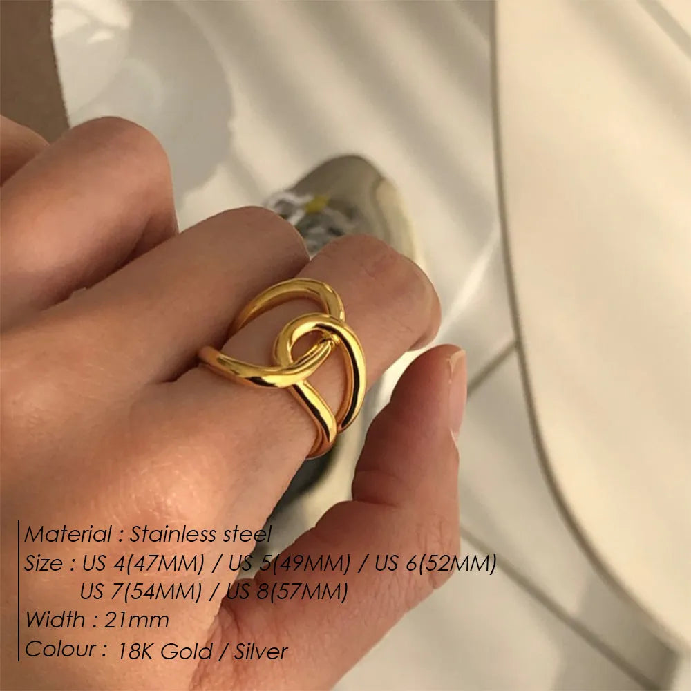 Women's stainless steel knotted geometric adjustable opening ring in gold or silver tone on a hand.