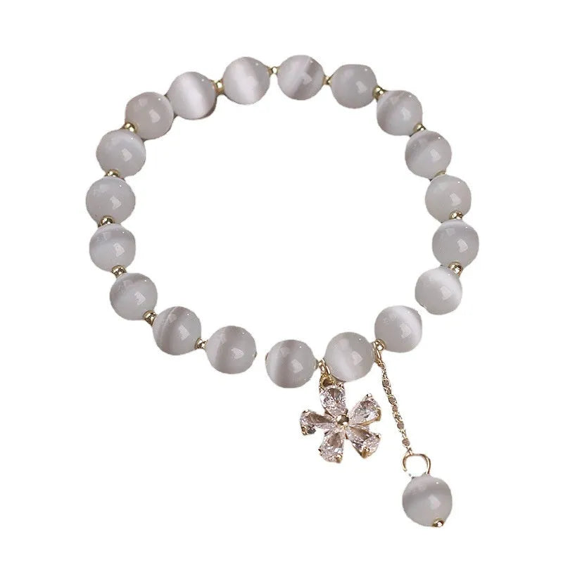 White cat's eye crystal bracelet with flower tassel and safety buckle for women.