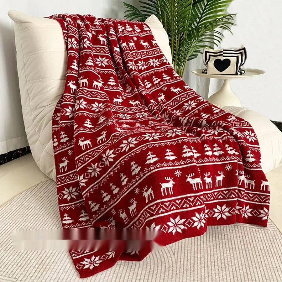 Personalised acrylic Christmas blanket with snowflake or reindeer pattern on a sofa.