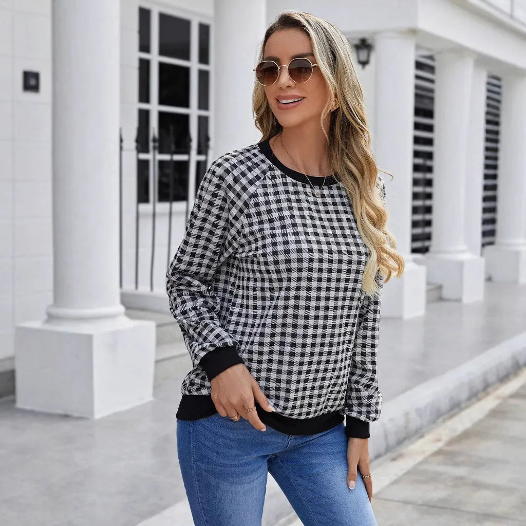 Black plaid pattern long sleeve polyester pullover sweater on a hanger.