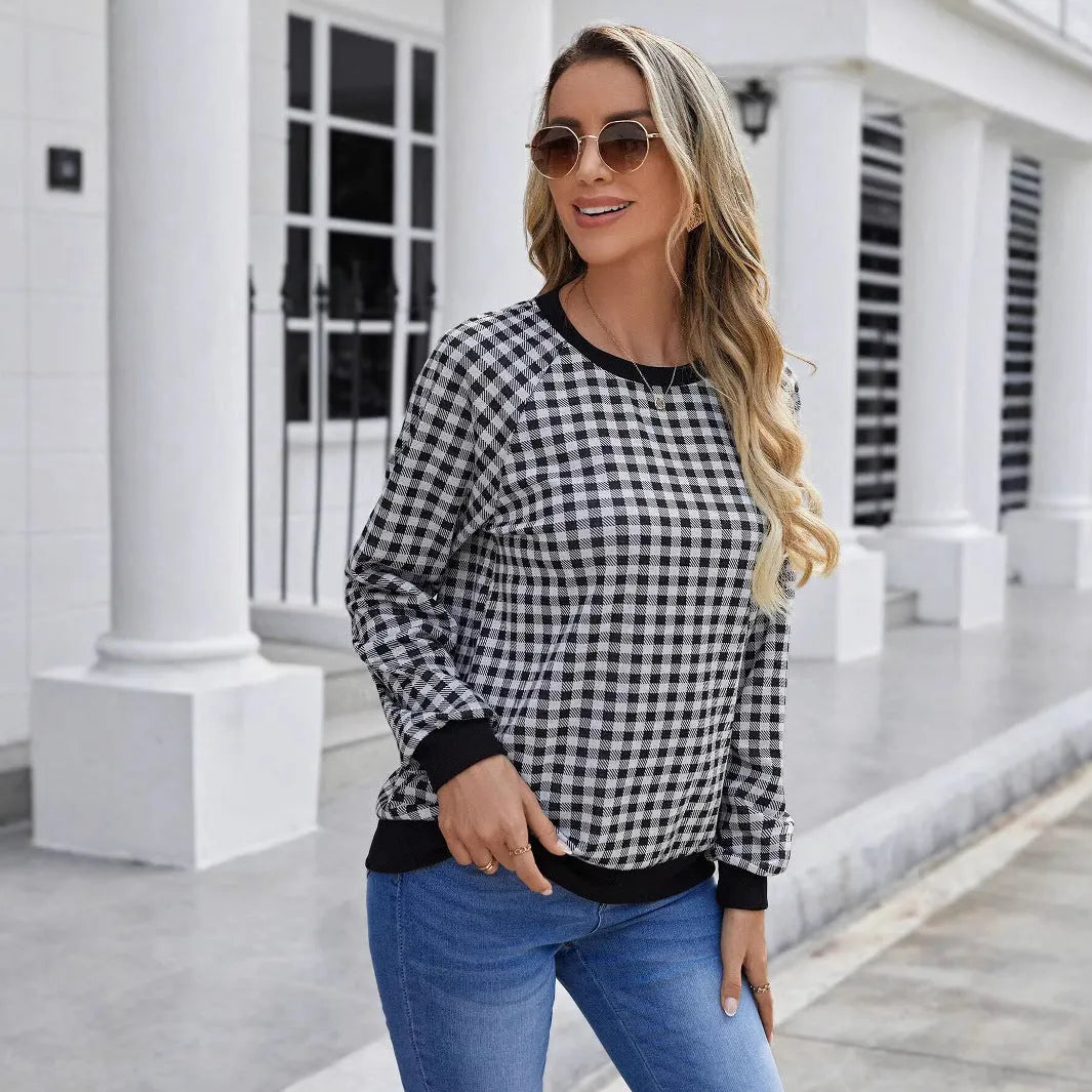 Black plaid pattern long sleeve polyester pullover sweater on a hanger.