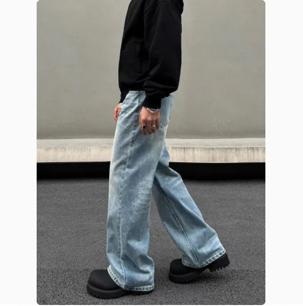 Men's blue straight leg jeans with a retro whisker wash, showing flared leg and visible stitching.