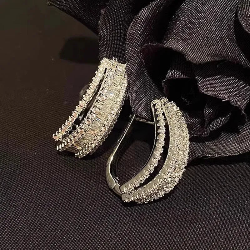A pair of geometric-shaped stud earrings with zircon stones in a white gold colour.