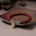 Handmade wave-shaped bracelet made from cinnabar and copper beads in a national unisex style.
