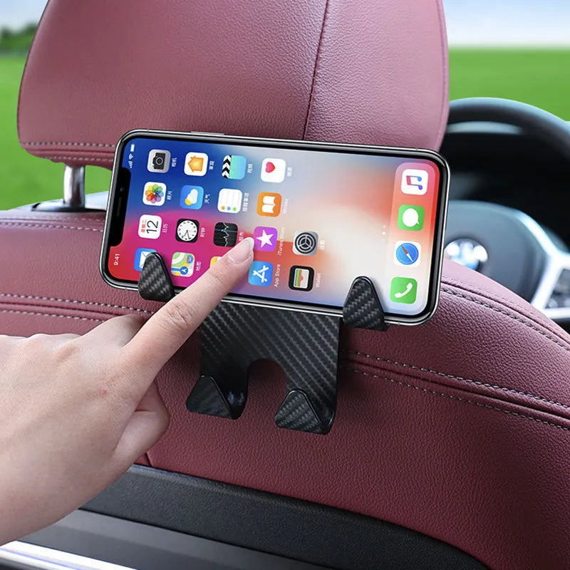 Black ABS car storage hook with carbon fibre pattern, combining a bag hook and mobile phone holder for rear seat installation.