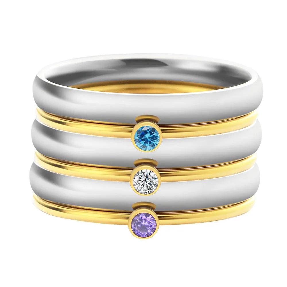 December birthstone geometric engraved ring in titanium steel with gold-coloured handle on a grey background.