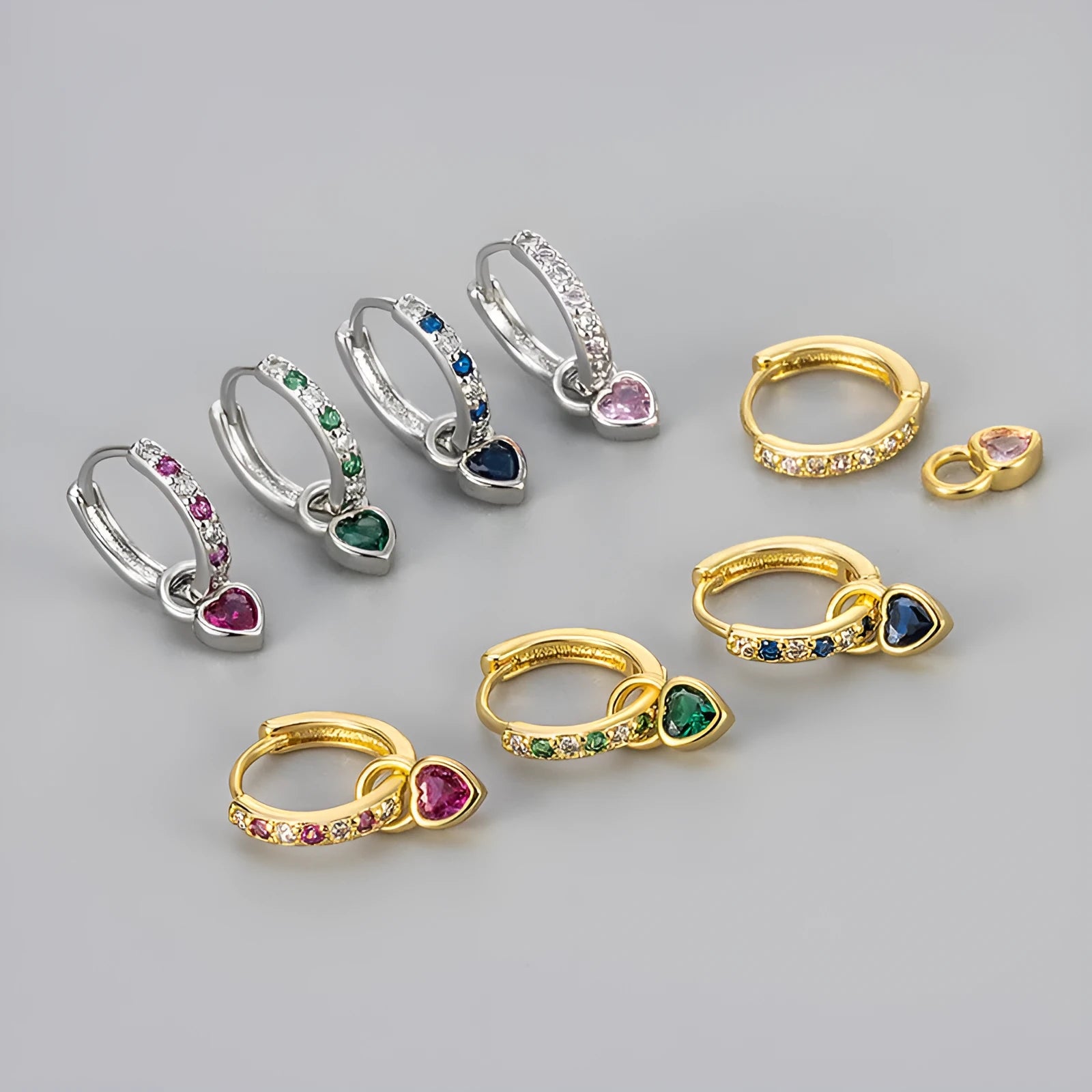 A pair of women's dangle earrings with a heart-shaped frame holding a coloured zircon stone.