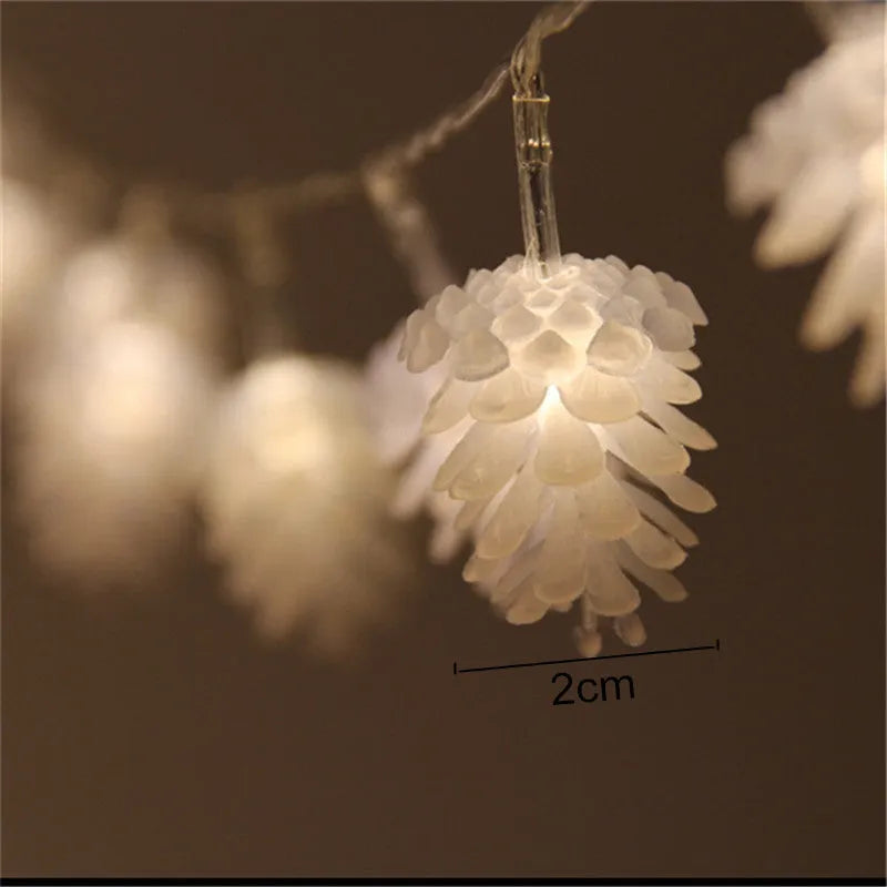 Warm white battery-powered LED pine cone lights on a string for festive decoration.