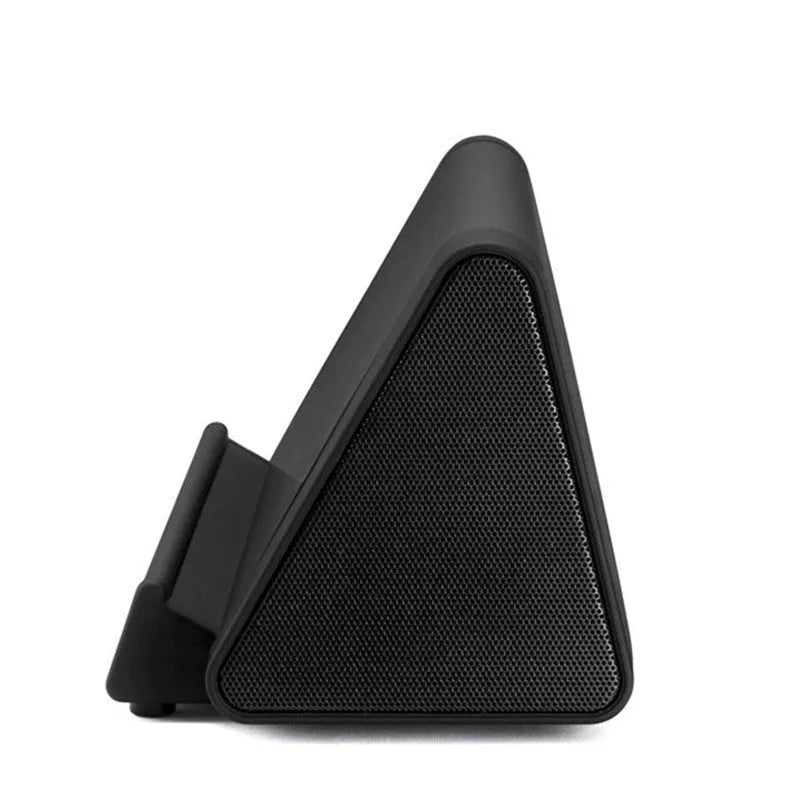 Small black and white wireless Bluetooth speaker with built-in charging cable.