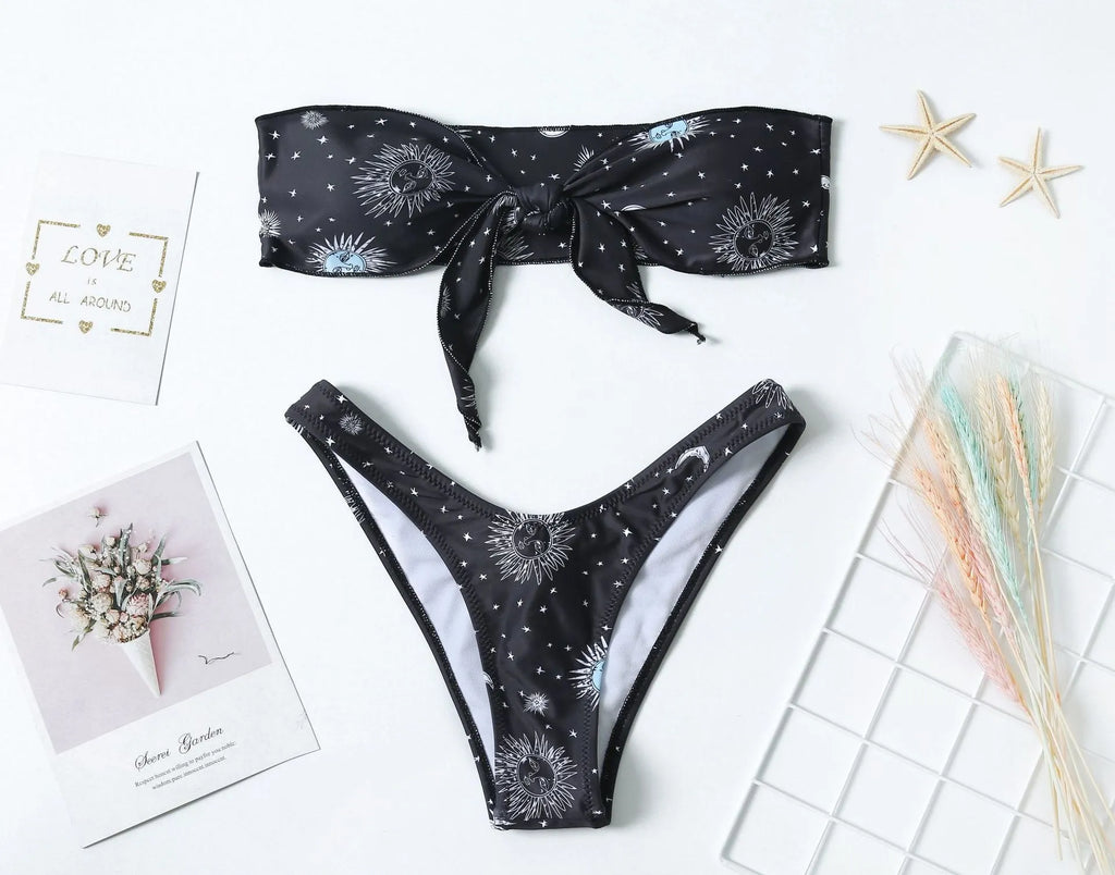 Black one-piece swimsuit with a bikini print pattern and a backless design.