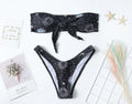 Black one-piece swimsuit with a bikini print pattern and a backless design.